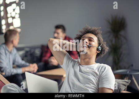 Laughing african american hipster software developer at computer at office of startup company Stock Photo