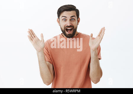 Waist-up shot of enthusiastic happy and triumphing delighted 30s male with beard widen eyes amazed and pleased clapping hands from delight and satisfa Stock Photo