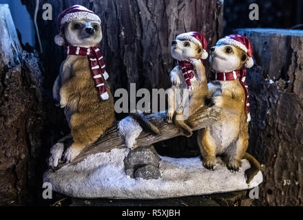 Berlin, Germany. 27th Nov, 2018. Three meerkat figures disguised as Santa Clauses stand in a garden in Berlin. Credit: Paul Zinken/dpa/Alamy Live News Stock Photo
