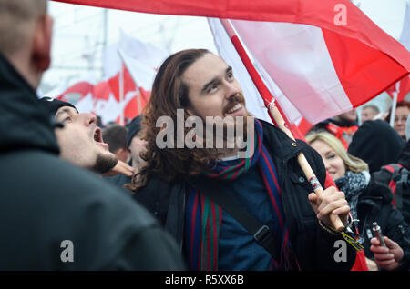 A man holds the Polish flag and smiles, Polish National Independence Day march, 100 year anniversary, Warsaw, 11 November, Poland, 2018 Stock Photo