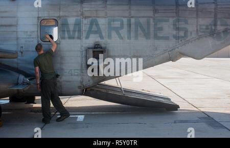 Marine Corps Cpl. Alexander Keegan, a flight line mechanic with Marine Heavy Helicopter Squadron (HMH) 466, cleans the window of a CH-53E Super Stallion during Weapons and Tactics Instructors course (WTI) 2-17 at Naval Air Facility El Centro, Calif., April 14, 2017. WTI is held biannually at Marine Corps Air Station (MCAS) Yuma, Ariz. to provide students with detailed training to be practiced on the various ranges in Arizona and California. Stock Photo