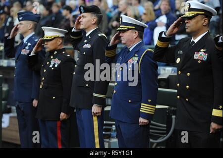 Capt. Brendan McPherson (second to right), chief of staff, Coast Guard 13th District, along with VIP representatives from the other four U.S. armed forces and the Washington Army National Guard, salute during the nation anthem at the Mariners' 15th Annual Salute to Armed Forces Night at Safeco Field in Seattle, April 15th, 2017.    McPherson participated as the Coast Guard representative during the plaque presentation portion of the opening ceremony.