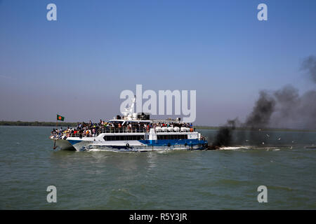 A catamaran vessel takes tourists from Teknaf to St Martin's Island, belching black smoke on the way. Cox's Bazar, Bangladesh. Stock Photo