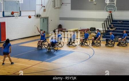 A line of Warrior CARE athletes line up to take their shot during a wheelchair basketball session at the adaptive sports camp at Eglin Air Force Base, Fla., April 24. The base hosts the week-long Wound Warrior CARE event that helps recovering wounded, ill and injured military members through specific hand-on rehabilitative training. Stock Photo