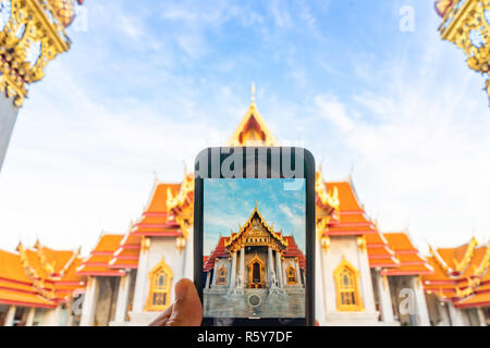Taking photo Thai Marble Temple (Wat Benchamabophit Dusitvanaram) with mobile phone  in Bangkok, Thailand Stock Photo