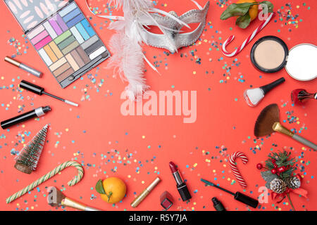 Photo on top of eye shadows, brushes, feather mask, tangerine, sugar cane, confetti Stock Photo