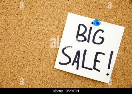A yellow sticky note writing, caption, inscription Phrase BIG SALE in black ext on a sticky note pinned to a cork notice board Stock Photo