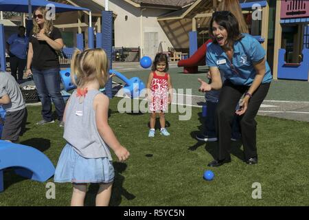 Kristyn Fleming, right, operations assistant for the Armed Services Young Men's Christian Association (ASYMCA) plays with the children of the ASYMCA Fisher Children's Center during a 'Week of Play' event on Camp Pendleton, Calif., April 20, 2017. The ASYMCA, fisher Children's Center, was awarded a Kaboom Play Grant from the CarMax Foundation for Military Child Month where an 'imagination playground' was revealed. Stock Photo