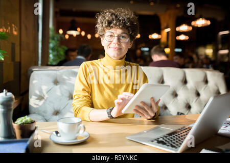 Attractive hipster lady working with tablet in restaurant Stock Photo