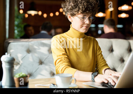 Serious hipster woman typing on laptop Stock Photo