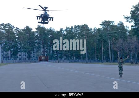 ADAZI, Latvia – Soldiers from Company C, 1st Battalion, 501st Aviation Regiment, 1st Armored Division out of Fort Bliss, Texas attached to Task Force Falcon, land their AH-64D Apache attack helicopter at the parade field on Ādaži military base during Operation Summer Shield as a part of Operation Atlantic Resolve, April 24, 2017. As part of Operation Summer Shield the pilots and crew briefed the Joint Terminal Attack Controller (JTAC) crews stationed at Ādaži Military base, which consisted of U.S. Army and Air Force as well as Latvian armed forces, of the capabilities the Apache attack helicop Stock Photo