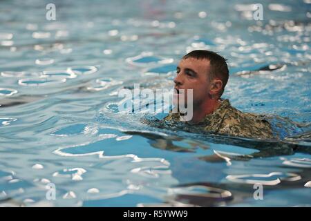 U.S. Army Sgt. Anthony Barba, 184th Headquarters and Headquarters Detachment (EOD), 184th Ordnance Disposal Battalion (EOD), 52nd Ordnance Group (EOD), stops to catch his breath during the 100 meter swim portion of the German Armed Forces Proficiency Badge (GAFPB) at Central Washington University, Ellensburg, Wash., April 23, 2017. The GAFPB swim requires participants to swim in uniform, without boots, for 100 meters in under four minutes, then remove the uniform in the deep end without holding the edges of the pool. Stock Photo