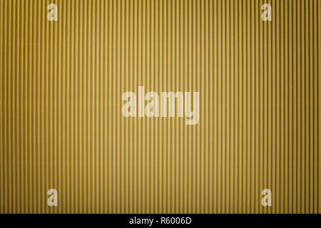 Texture of corrugated dark golden paper with vignette, macro. Striped pattern of yellow cardboard background, closeup. Stock Photo