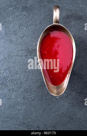 Cranberry sauce in a gravy boat on gray slate close-up Stock Photo