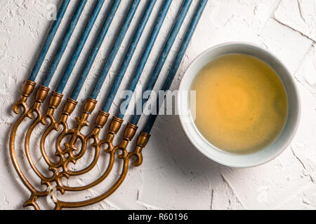 Fragment of Hanukkah with blue candles and butter in a bowl Stock Photo