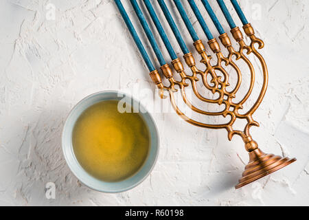 Fragment of Hanukkah with blue candles and butter in a bowl top view Stock Photo