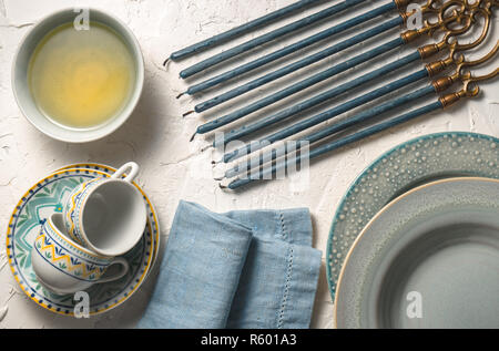 Hanukkah with candles, plates, butter in a bowl and blue napkin Stock Photo