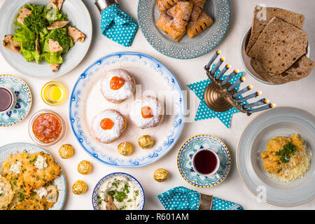 Hanukkah with candles, plates, butter in a bowl and blue napkin top view Stock Photo