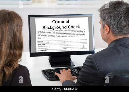 Two Businesspeople Looking At Calendar On Computer Stock Photo