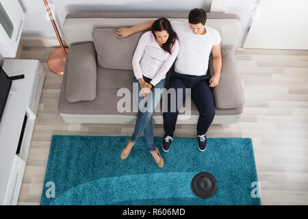 Couple Using Cleaner Robot Stock Photo