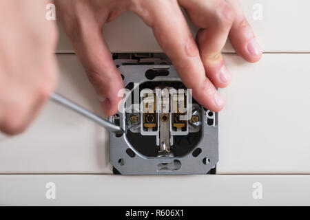 Person's Hand Repairing Electrical Socket Stock Photo