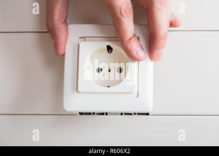 Person's Hand Repairing Electrical Socket Stock Photo