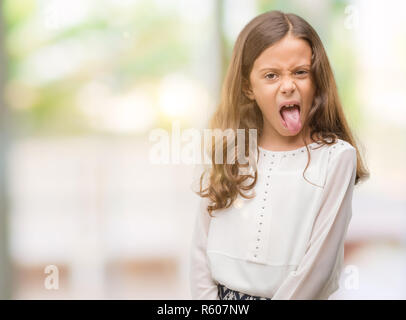 Brunette hispanic girl sticking tongue out happy with funny expression. Emotion concept. Stock Photo