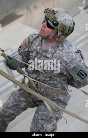 U.S. Army Sgt. Anthony Barba, 184th Headquarters and Headquarters Detachment (EOD), 184th Ordnance Disposal Battalion (EOD), 52nd Ordnance Group (EOD), receives instructions before lowering himself during a vertical access training exercise at Yakima Fire Station 95, Yakima, Wash., April 25, 2017. The vertical access training is designed to create adaptive leaders capable of solving various threats in hostile and friendly environments. Stock Photo