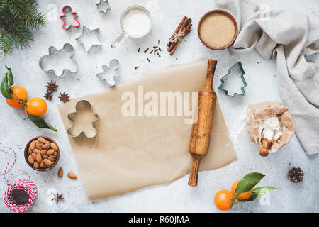 Christmas Baking Concept. Cookie Cutters, Rolling Pin, Baking Paper And Ingredients On Concete Background. Top View Gingerbread Cookies Baking. Copy S Stock Photo
