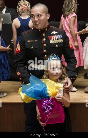 U.S. Marine Corps Sgt. Zachary R. Marulitua, critical skills operator, Headquarters and Service Company, 1st Marine Raider Battalion, Marine Special Operations Command, wins a raffle with his daughter, six year old Grace Marulitua, during the 11th annual father-daughter dance on Camp Pendleton, Calif., April. 28, 2017. The father-daughter dance is an annual event held for active duty, reserve and veteran fathers to bond and have fun with their daughters. Stock Photo