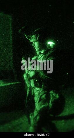 U.S. Army Sgt. Anthony Barba, 184th Headquarters and Headquarters Detachment (EOD), 184th Ordnance Battalion (EOD), 52nd Ordnance Group (EOD), prepares to send information over the radio during a night operation for a situational training exercise (STX) lane at the Yakima Training Center, Yakima, Wash., April 26th, 2017. The final days of the CBRNE Leaders Course are comprised of STX lanes that test what the Soldiers' learned throughout the duration of the course. Stock Photo