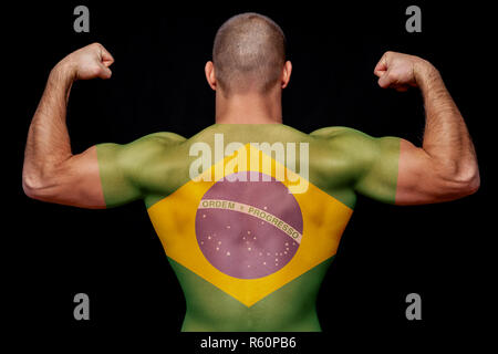 The back of a young sports man wearing a T-shirt with the Brazil national flag on a black isolated background. Concept of national pride and patriotis Stock Photo