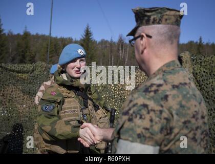 U.S Marine Col. Doug Bruun meets with a cadet of the Royal Norwegian Air Force Academy during a mock United Nations exercise in Giskaas, Norway, April 25, 2017. The cadets briefed Bruun on each of their post’s status and organization. Marine Rotational Force Europe 17.1 (MRF-E) galvanizes the Marine Corps’ long and close relationship with the Norwegian Armed Forces. Stock Photo