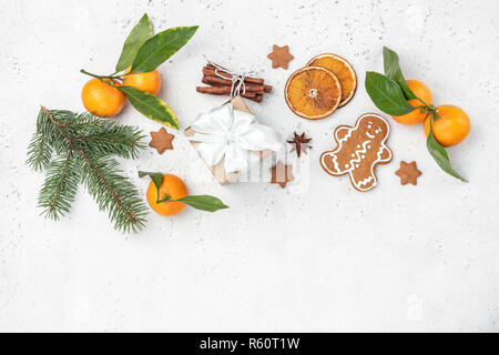 Winter or Christmas decoration symbols. Tangerines, gingerbread, fir tree, cinnamon, gift box. Top view copy space for text Stock Photo