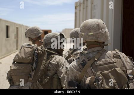 U.S. Marines with 3rd Platoon, Fox Company, 2nd Battalion, 6th Marine Regiment, take cover from enemy fire by opposing forces while conducting Military Operations in Urban Terrain (MOUT) for Talon Exercise (TalonEx) 2-17, Twentynine Palms, CA., April 26, 2017. The purpose of TalonEx was for ground combat units to conduct integrated training in support of the Weapons and Tactics Instructor Course (WTI) 2-17 hosted by Marine Aviation Weapons and Tactics Squadron One (MAWTS-1). Stock Photo