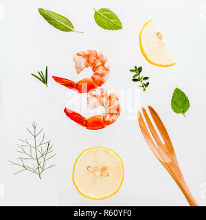 Fresh steamed shrimp isolate on white background. Boiled prawns with ingredients. Boiled prawns with herbs Fennel ,parsley,rosemary,lemon and mint with fork isolate on white background. Stock Photo