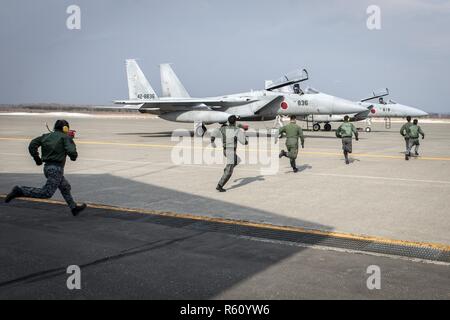 Koku-Jieitai pilots race to two Mitsubishi F-15J Eagles during a scramble demonstration as part of a 10-day U.S.-Japan Bilateral Career Training at Chitose Air Base, Japan, April 14, 2017. The scramble showcased the 2nd Air Wing’s response capability to outside threats as the installation responds to incursions into Japanese airspace every week. The F-15Js offer the Koku-Jieitai a twin-engine, all-weather air superiority fighter based on the U.S. Air Force’s McDonnell Douglas F-15 Eagle. Koku-Jieitai is the traditional term for Japan Air Self Defense Force used by the Japanese military. Stock Photo