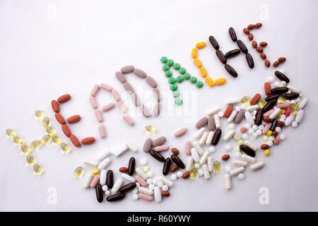Hand writing text caption inspiration Medical care concept written with pills drugs capsule word headache On white isolated background with copy space Stock Photo
