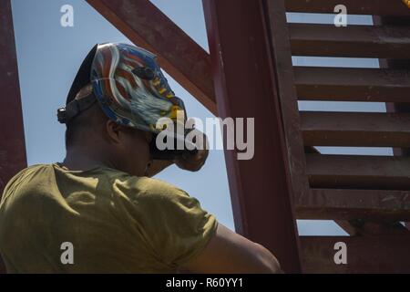 Philippine Army Pfc. Leo Genn Layson removes his welding helmet after working at a construction site for a humanitarian civic action project during Balikatan 2017 at Duran Elementary School in Dumalag, Capiz, April 29, 2017. Layson is a welder with the 53rd Engineer Brigade, Philippine Army. Balikatan is an annual U.S.-Philippine bilateral military exercise focused on a variety of missions, including humanitarian assistance and disaster relief, counterterrorism, and other combined military operations. Stock Photo