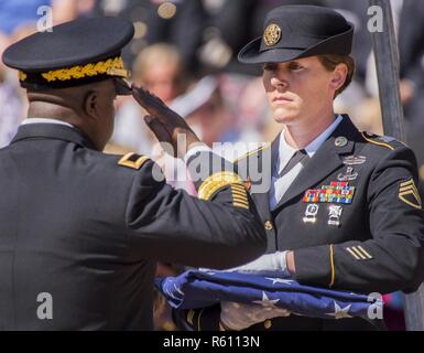 Brig. Gen. David Wilson, U.S. Army Ordnance School commandant, salutes before receiving a folded American flag during the 48th Annual Explosive Ordnance Disposal Memorial Service, May 6. Names of recent fallen and past EOD technicians are added to the memorial wall during a ceremony each year at the Kauffman EOD Training Complex at Eglin Air Force Base, Fla. The Army and Navy added six new names this year. The all-service total now stands at 326. Stock Photo