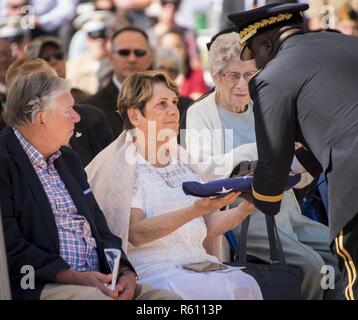 Brig. Gen. David Wilson, U.S. Army Ordnance School commandant, presents a folded flag to Margaret Lauterjung, sister of Army Tech. Sgt. James Eberle, during the 48th Annual Explosive Ordnance Disposal Memorial Service, May 6. Eberle and other names of recent fallen and past EOD technicians are added to the memorial wall during a ceremony each year at the Kauffman EOD Training Complex at Eglin Air Force Base, Fla. The Army and Navy added six new names this year. The all-service total now stands at 326. Stock Photo