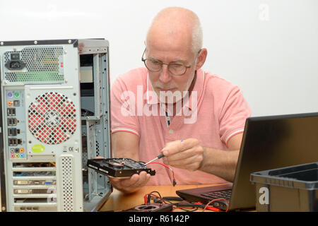 man technician working on broken computer Stock Photo