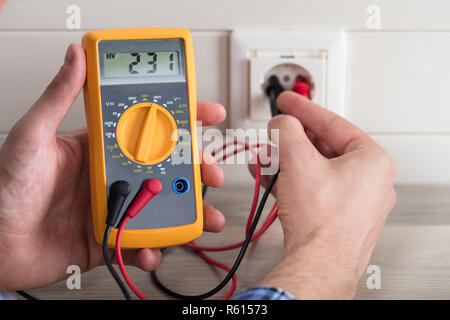 Male Electrician Checking Voltage Of Socket With Multimeter Stock Photo