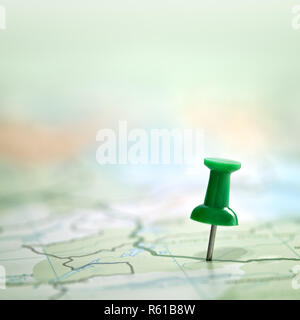 Pushpin showing the location of a destination point on a green map