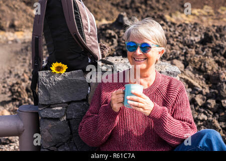senior aged attractive third age woman smile and enjoy the outdoor vacation travel with backpack to feel the freedom and the independence from the soc Stock Photo