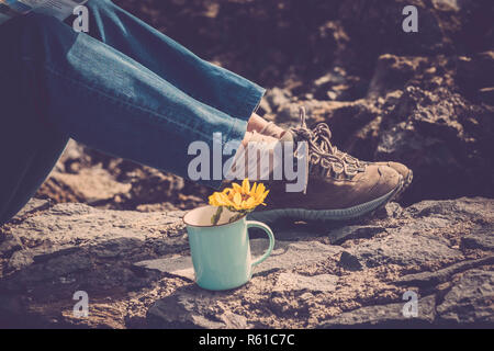 closeup of woman's trekking shoes on a rock during the excursion to feel the freedom and walk on the mountain - concept of independence and spirit of  Stock Photo