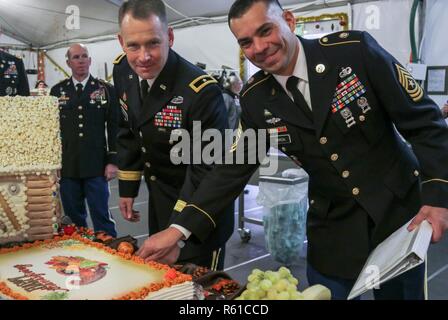 Brig. Gen. Todd R. Wasmund, 1st Infantry Division Atlantic Resolve Mission Command Element commander, and Sgt. Maj. Sael Garcia, senior enlisted advisor for 1st Infantry Division Atlantic Resolve Mission Command Element, cut the cake during Thanksgiving celebration at Poznan, Poland, Nov. 22, 2018. Unit leaders traditionally serve their Soldiers during Thanksgiving to demonstrate service and to express appreciation to Soldiers daily sacrifices. Stock Photo