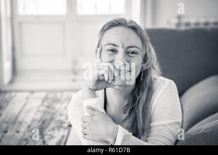 Portrait of beautiful caucasian woman with a bindi in the center of her forehead feeling happy and peaceful with her new healthy and spiritual lifesty Stock Photo