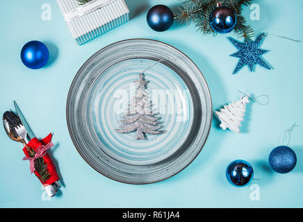Christmas table place setting on blue background. Holidays background. Stock Photo