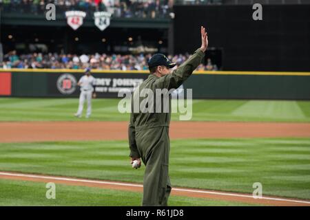 170505-N-ZO915-036 SEATTLE (May 5, 2017) Capt. Greg Huffman, USS John C. Stennis' (CVN 74) commanding officer, waves to fans as he takes the field to throw the ceremonial first pitch at a Seattle Mariners baseball game. Huffman threw out the first pitch at Safeco Field as part of “John C. Stennis Family Night” hosted by the Mariners and John C. Stennis’ Morale, Welfare, and Recreation department. John C. Stennis is conducting a planned incremental availability (PIA) at Puget Sound Naval Shipyard and Intermediate Maintenance Facility, during which the ship is undergoing scheduled maintenance an Stock Photo